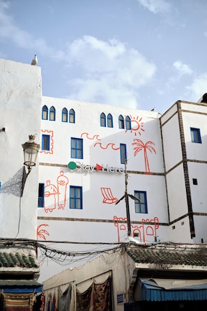 A building with multiple windows and a sign that reads 'Stay Here'.