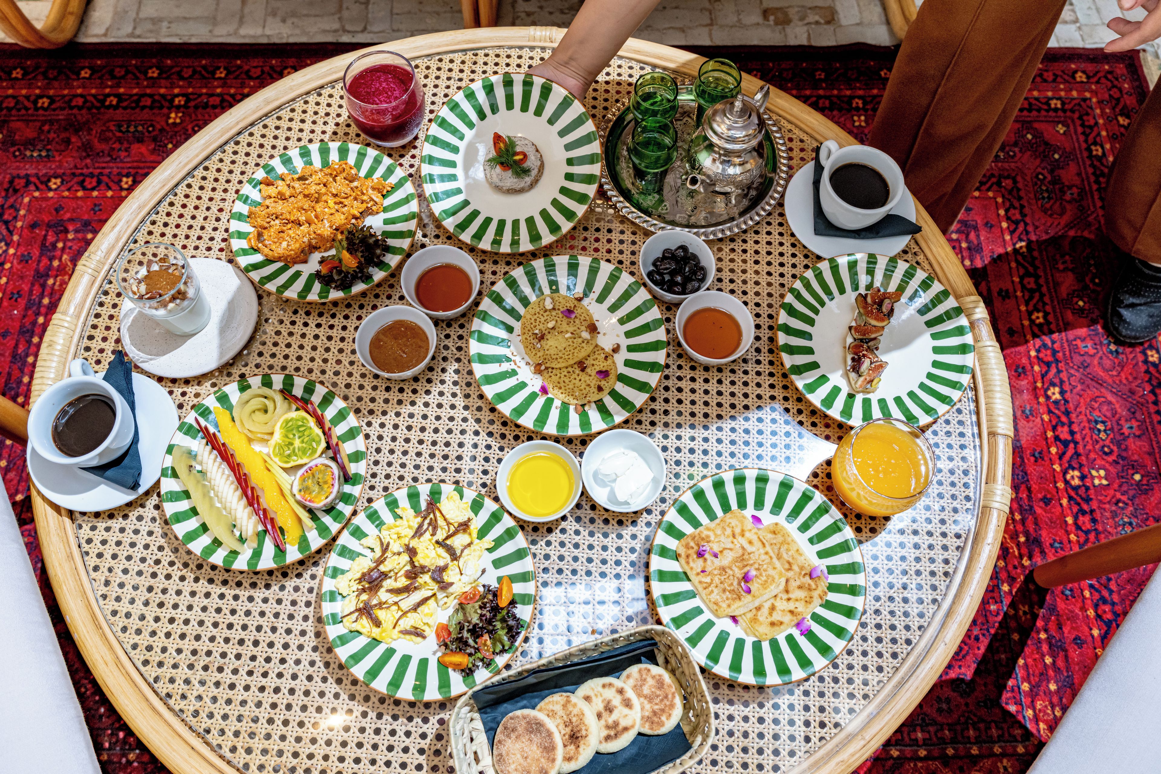 Mesa redonda con diversos platos y bebidas, evocando un ambiente de comedor compartido.
