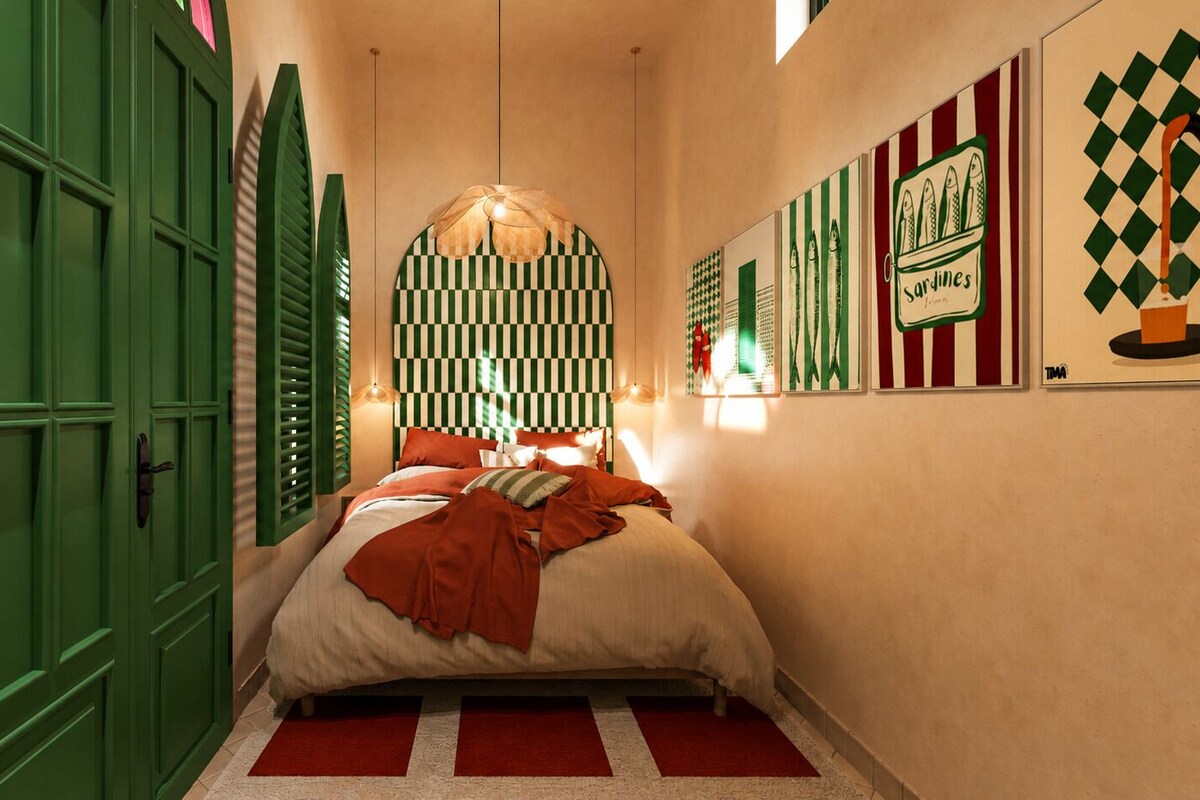 A bedroom with a bed, green doors, and wall art.