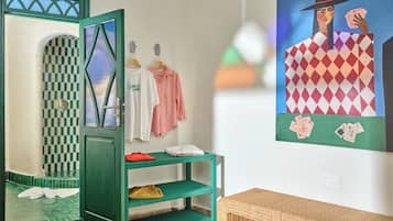 A room with a green door, a checkered wall, a white shirt, a striped shirt, and a painting of a woman with cards.