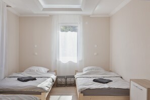 Ein Schlafzimmer mit zwei Betten, einem Fenster und einer Decke mit Dachfenstern.