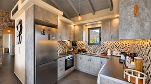 A modern kitchen with a large refrigerator, built-in oven, and a checkered backsplash. - Panoramic Sea View Villa near Galaxidi (Gerakofono Galaxidi)