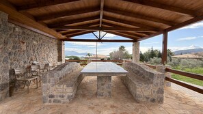 An outdoor covered patio with stone walls, a long table, and benches. - Panoramic Sea View Villa near Galaxidi (Gerakofono Galaxidi)