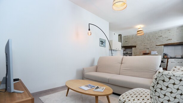 Una sala de estar moderna con un sofá, una mesa de centro y un televisor.