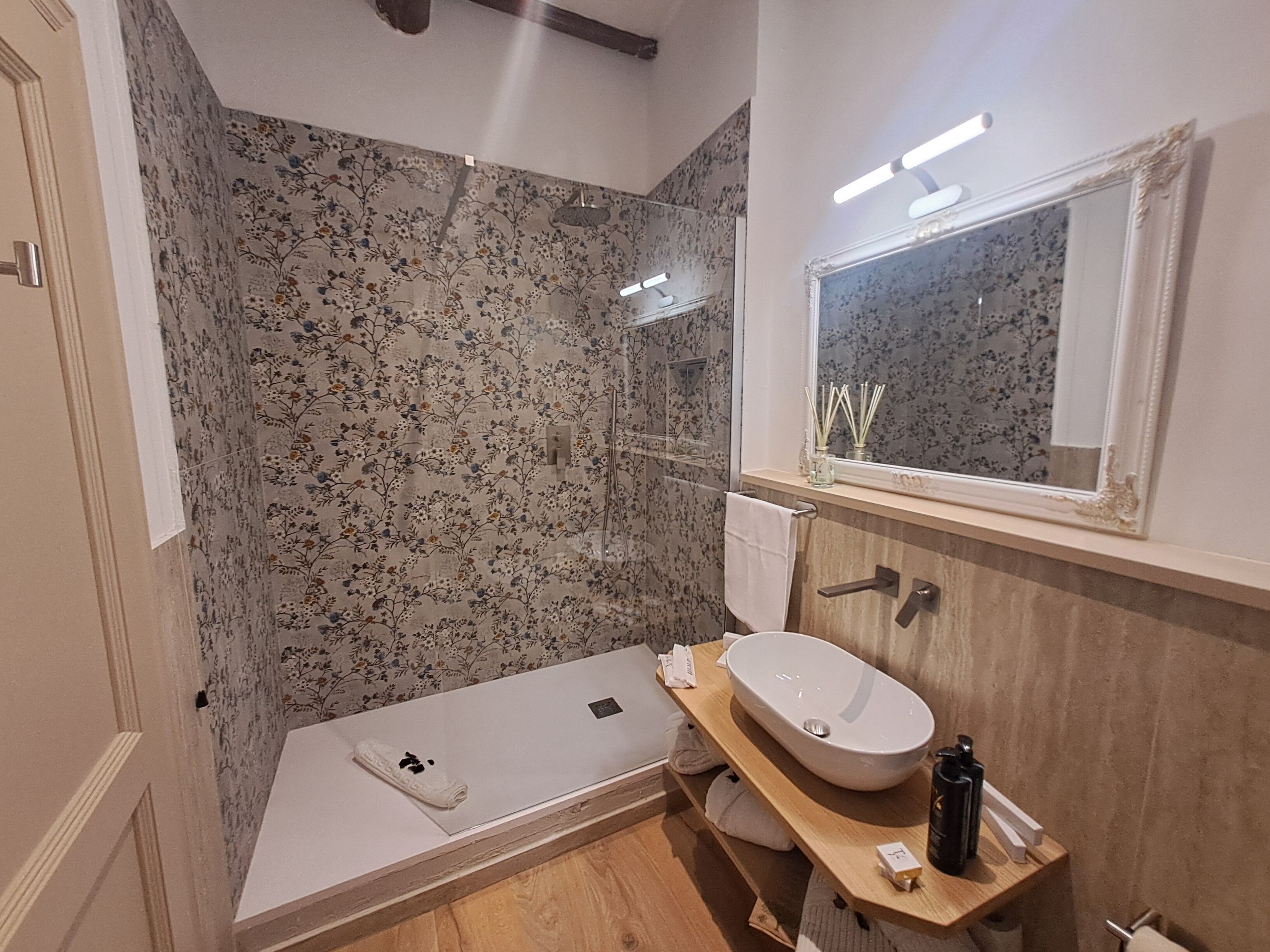 Un baño moderno con ducha, lavamanos y espejo.