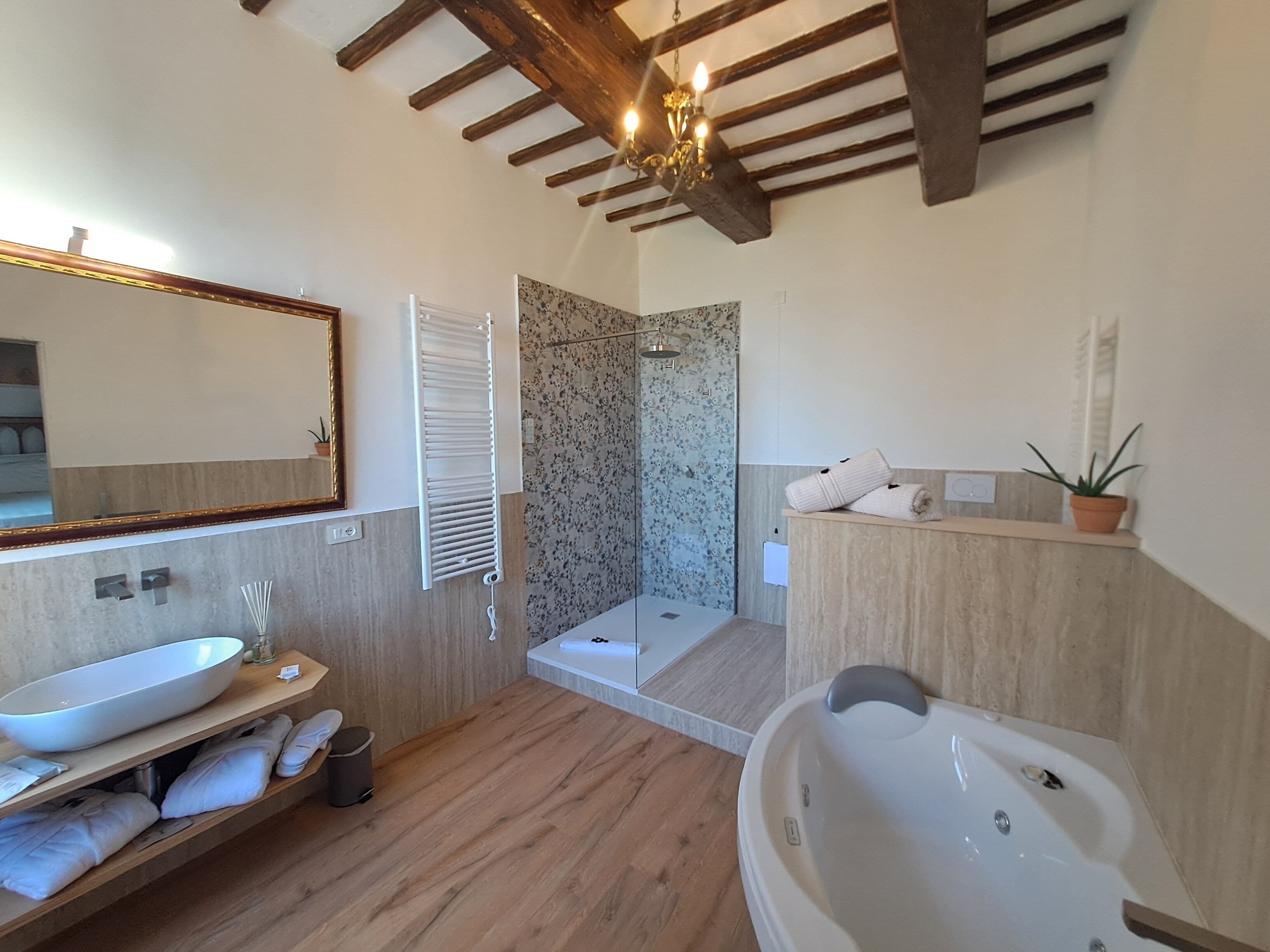 A modern bathroom with a large bathtub, a shower, and a vanity with a mirror.