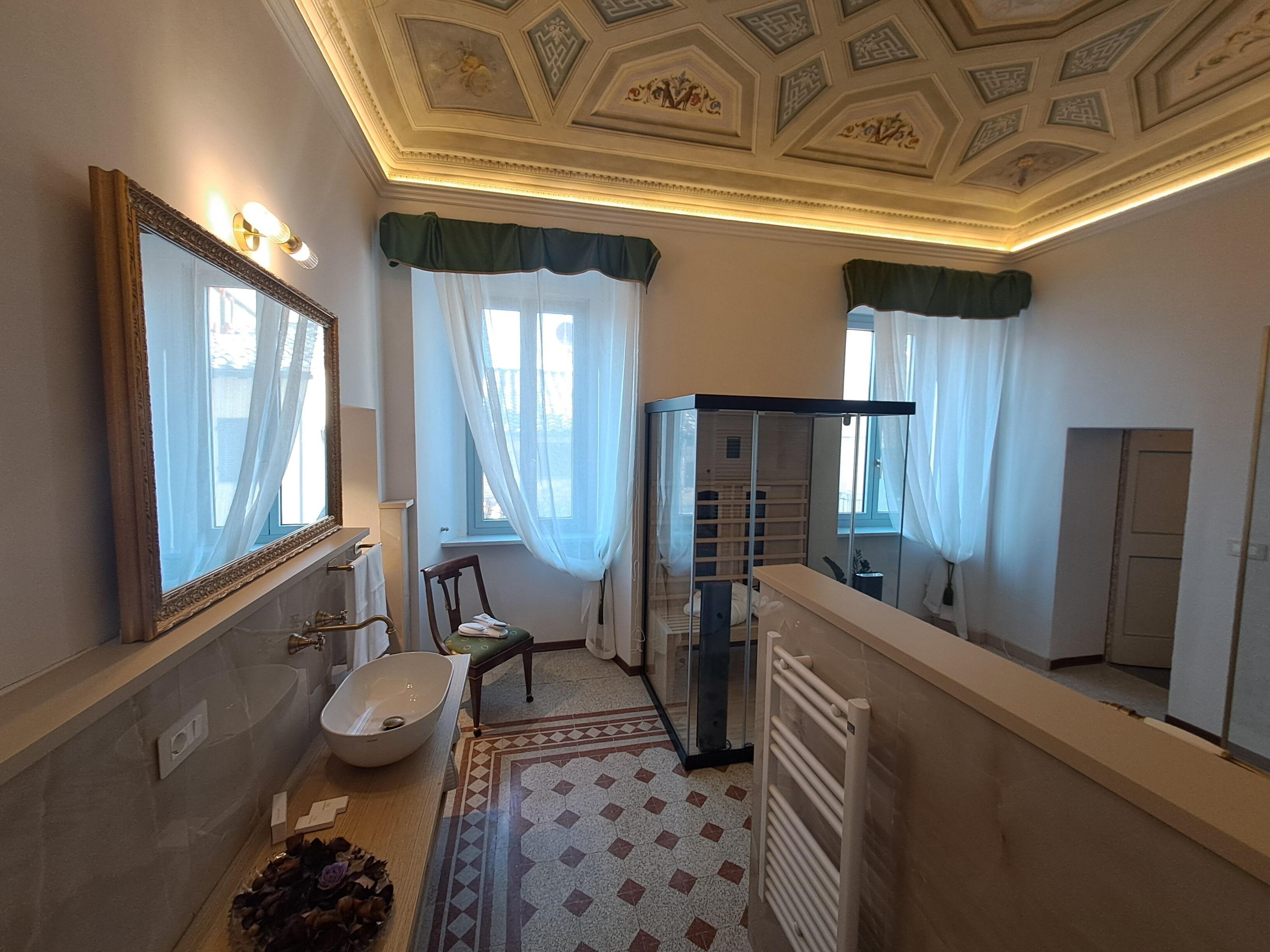 Ein Badezimmer mit Badewanne, Toilette, Waschbecken, Spiegel und Duschkabine.