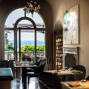 A dining area with a view of mountains, a chandelier, and a wine rack.