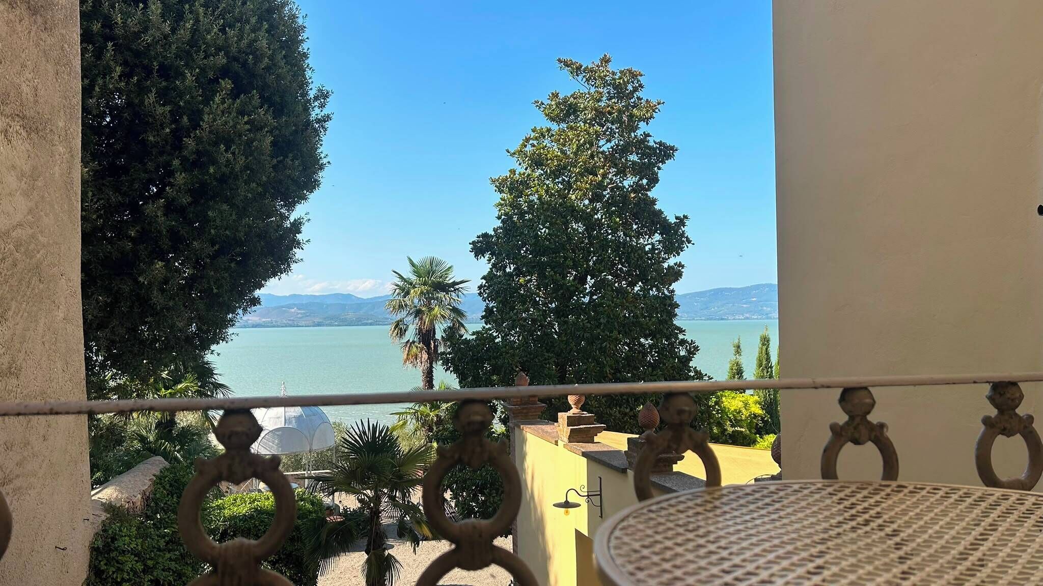 En balkon med udsigt over en sø og bjerge.