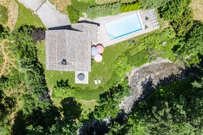 An aerial view of a property with a swimming pool, a covered patio, and a fenced yard. - Lodge Le Chevreuil - Piscine, jacuzzi et sauna (Le Grand Bornand)