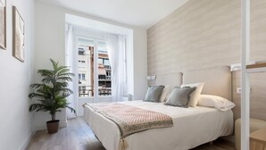 A bedroom with a bed, a potted plant, and a view of the outside. - Genteel Home Reina Sofia IV (Madrid)