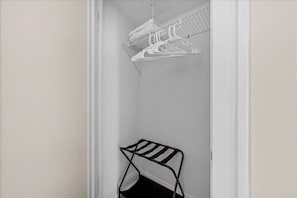 A closet with a metal rack and a hanging organizer.