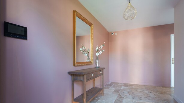 A hallway with a wooden console table, a large mirror, and two vases with flowers. - 180-square-meter house · Pool table · Air conditioning · Garden · Tours (Chambray-lès-Tours)