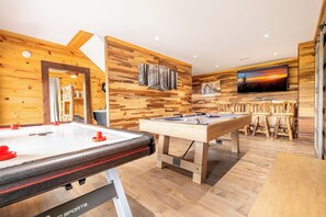 A pool table in a room with wooden walls and a television mounted above it. - Cloud Haven Retreat | Views, Hot Tub + Games (Gatlinburg)