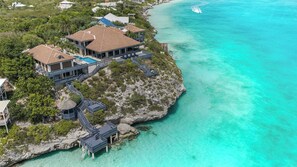A coastal property with a large house, multiple decks, and a swimming pool.