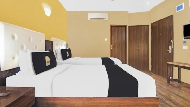 Une chambre d’hôtel comprenant un lit, un bureau, une chaise, une télévision et une armoire.