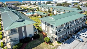A multi-story hotel with a pool, balconies, and a view of the ocean. - Spacious + In A Great Location Sandprints B1 (Miramar Beach)