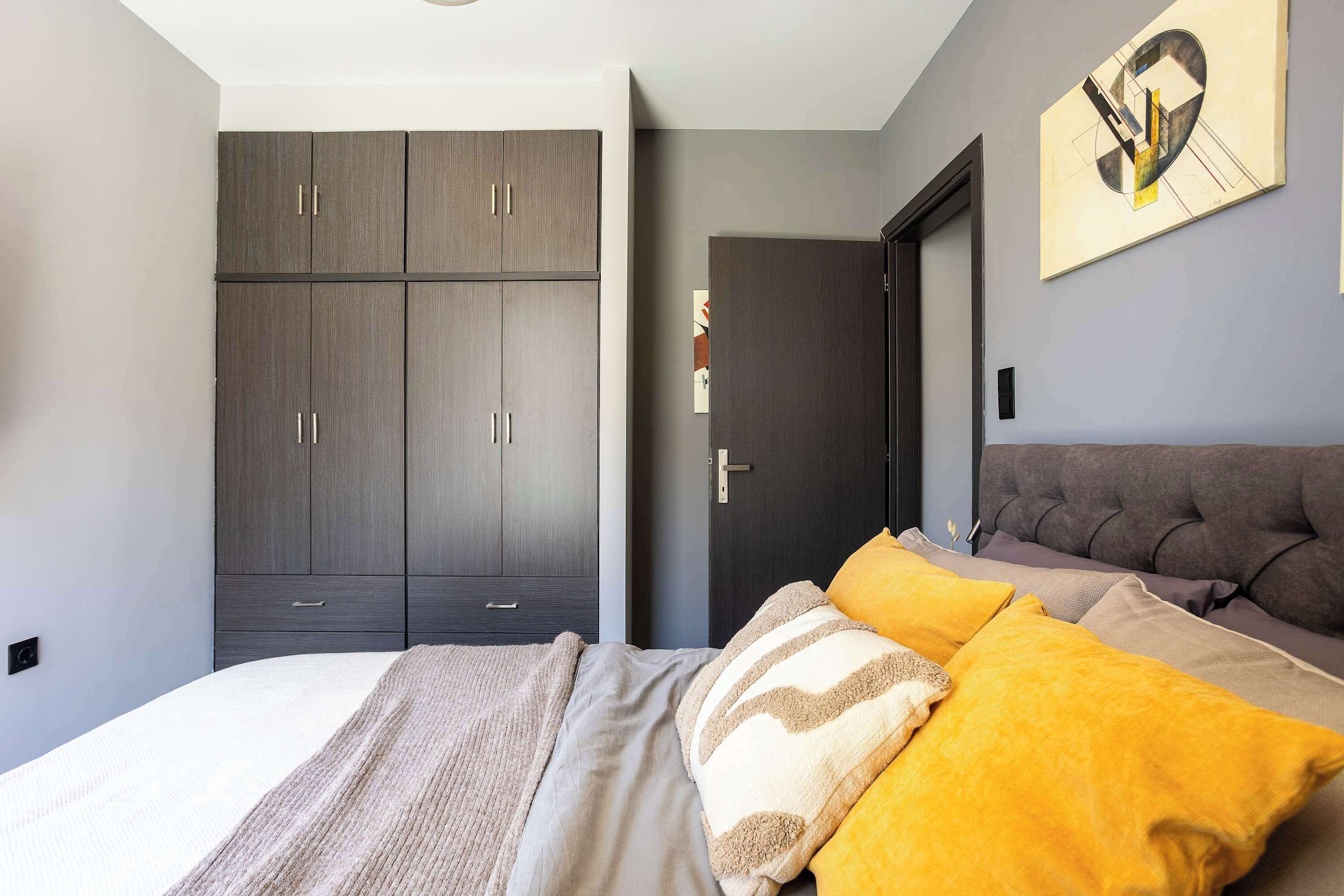 Une chambre à coucher avec un lit, une armoire et une porte.