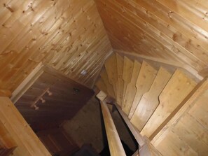 Eine Holztreppe mit Handlauf und Holzwänden.