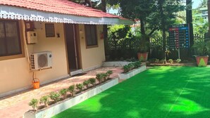 A building with a red-tiled roof, a small air conditioning unit, and a signboard with beverage options. - Ave maria Luxury Room and Apartment  (Colva)