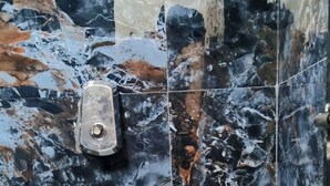 A bathroom with a toilet, marble walls, and a glass shower enclosure. - Ave maria Luxury Room and Apartment  (Colva)