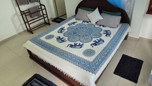 A bedroom with a bed, a hanging chair, a window with a curtain, and an air conditioning unit. - NATIVE SOULS Beach Hotel (Induruwa)