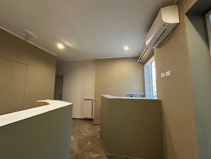 A hotel room with a kitchenette, a radiator, and a window with blinds. - Hotel Link Rho - JCUBE HOTELLERIE (Rho)