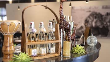 Eine Bar mit einer Holztrennwand, die mit Flaschen, einer Giraffenskulptur und Dekorationsgegenständen bestückt ist.