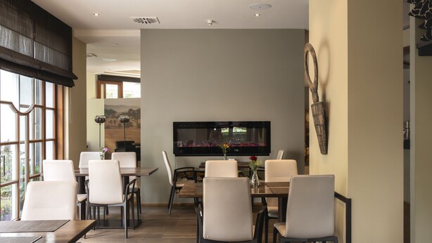 A dining area with a flat-screen TV mounted on the wall, surrounded by chairs and tables. - Modern Escape Near Badehaus Norderney & Weststrand Beach l 2 Units (Sundern (Sauerland))