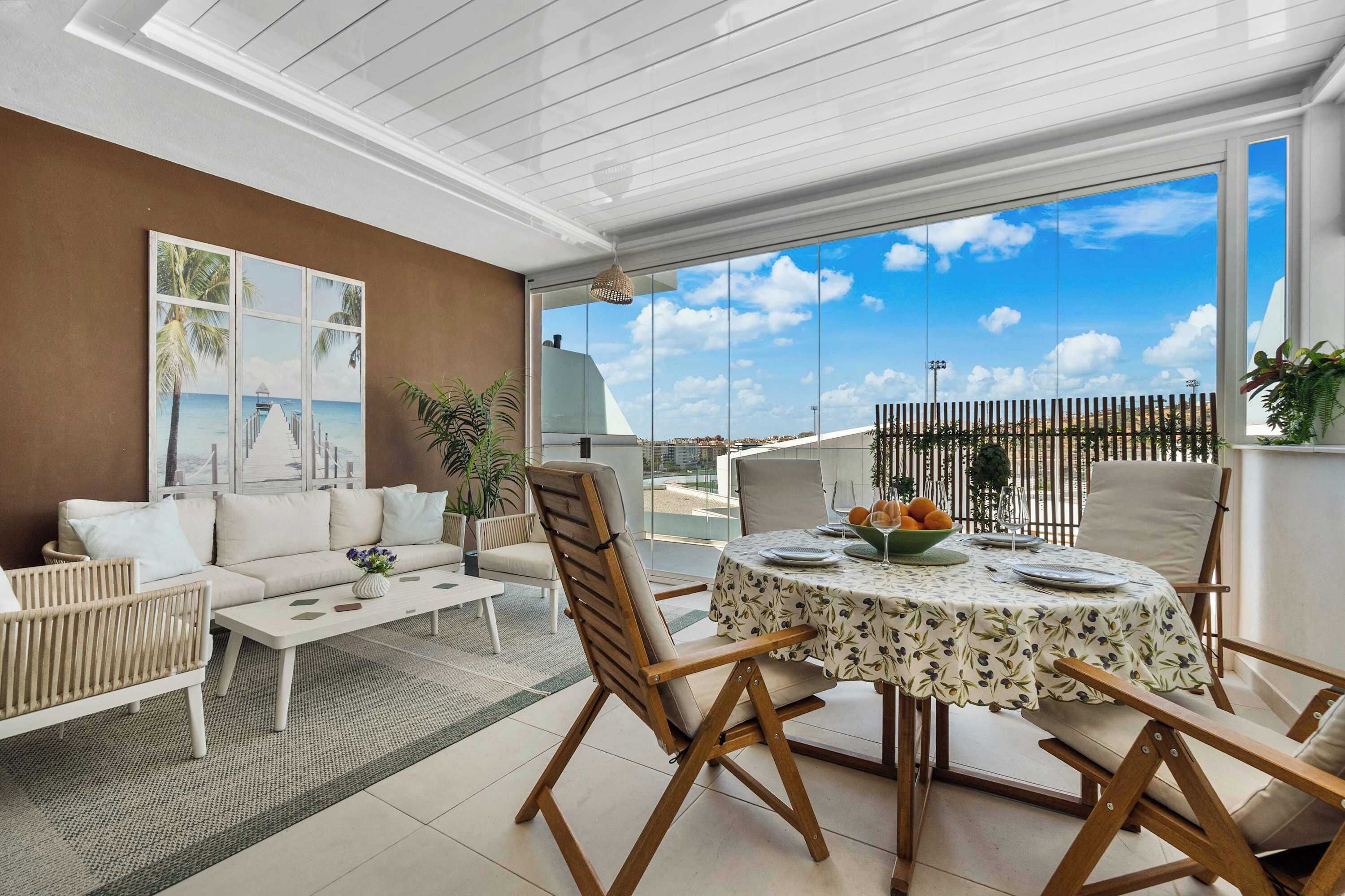 A modern living room with a sofa, coffee table, and dining area with chairs and a table set for a meal.