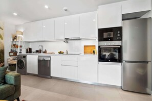 A modern kitchen with stainless steel appliances, a dishwasher, and a built-in oven. - Rooftop* Terrace*pool*parking* Town view (Estepona)