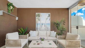 A room with a sofa, two armchairs, a coffee table, and a large window with a view of a pier. - Rooftop* Terrace*pool*parking* Town view (Estepona)
