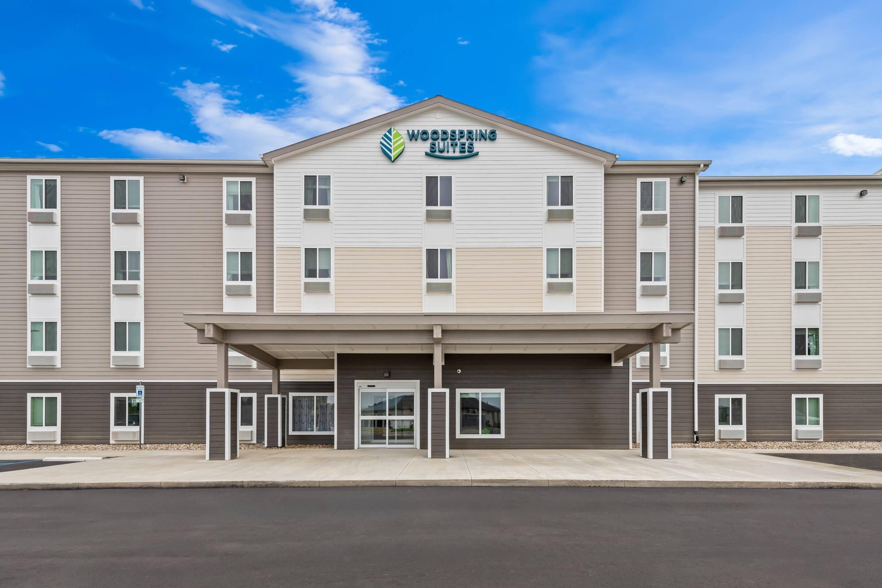 A multi-story hotel with a flat roof and a covered entrance area.