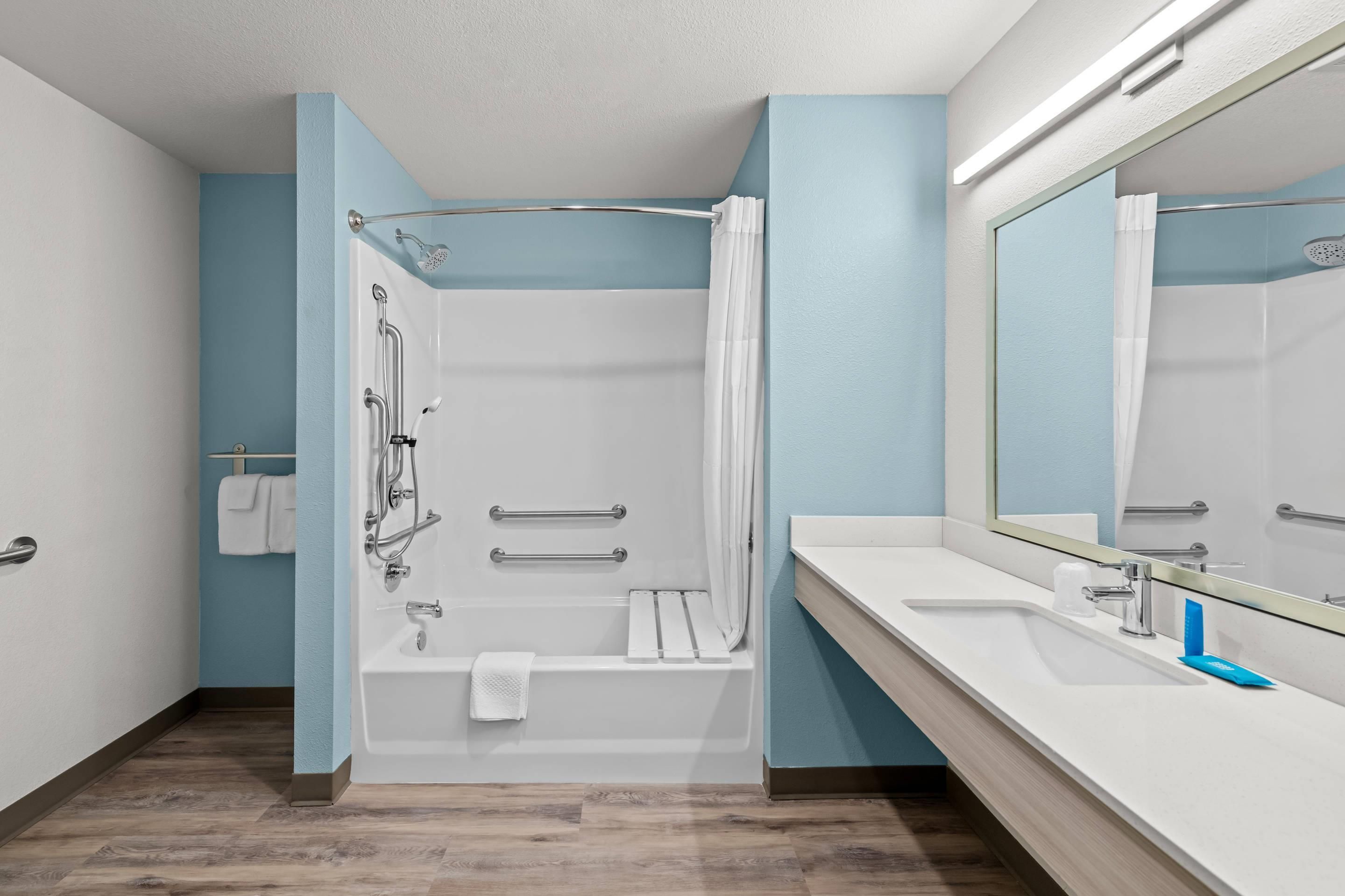 Une salle de bain équipée d’une douche, d’une baignoire et d’un meuble-lavabo avec un miroir.