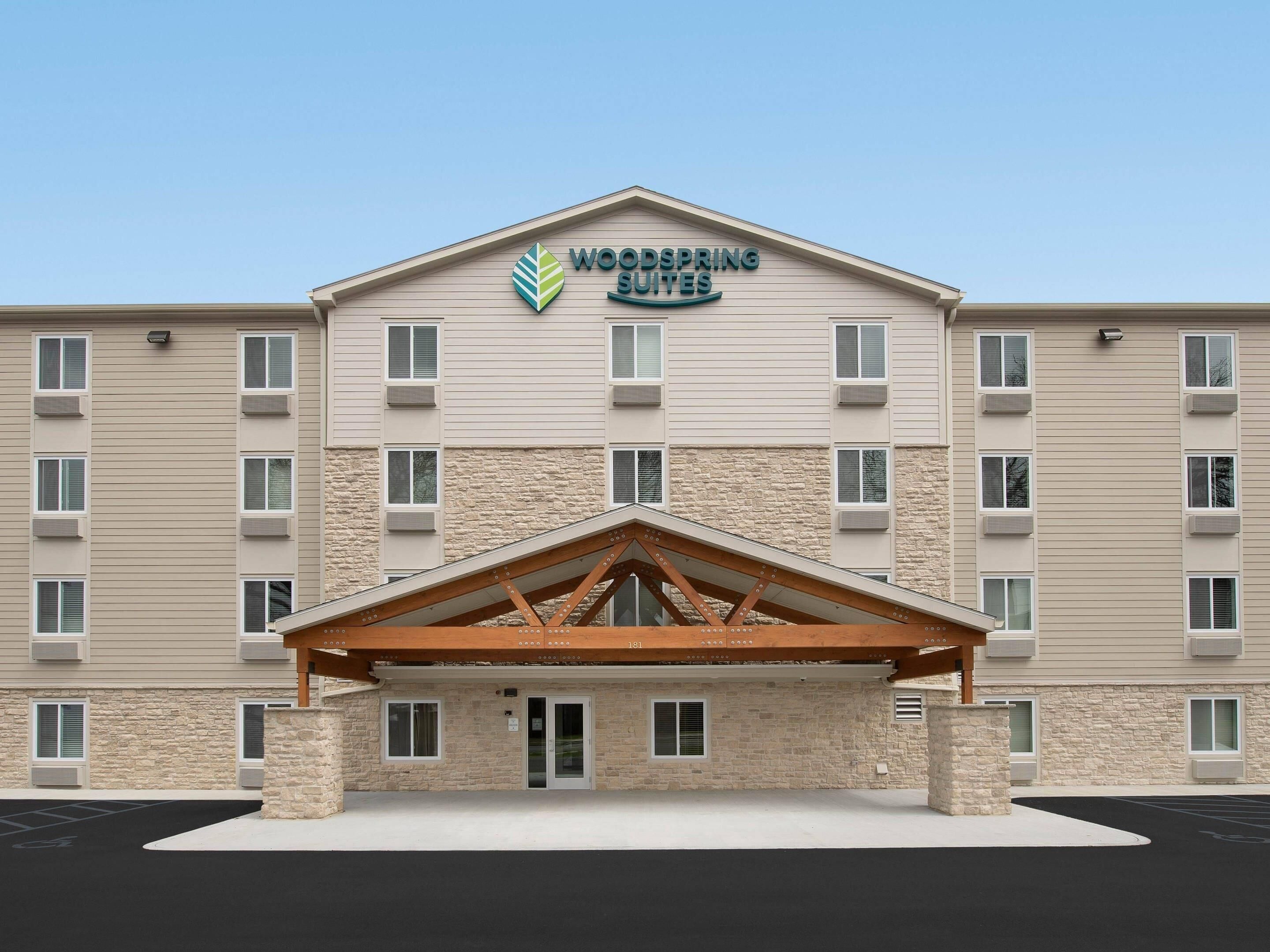 A hotel with a stone facade, multiple windows, and a central entrance with a wooden canopy.