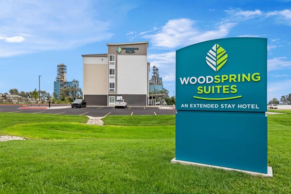 Señal de hotel para WoodSpring Suites, con vista despejada del edificio al fondo.