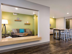 A modern living area with a sofa, coffee table, and a dining table with chairs.