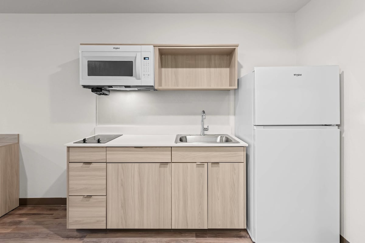 A compact kitchen with a microwave, sink, and refrigerator.