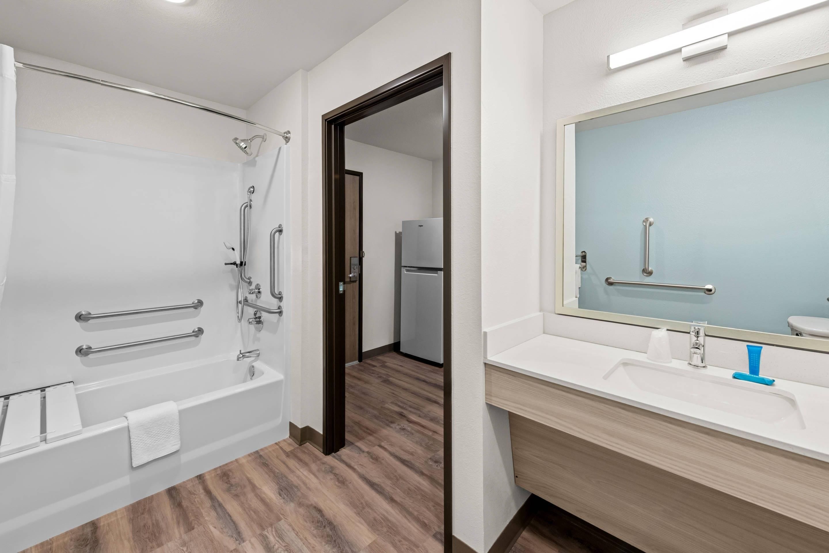 Un baño moderno con bañera, ducha y tocador con espejo.