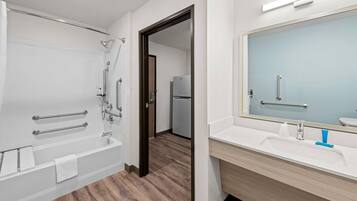 Un baño moderno con bañera, ducha y tocador con espejo.