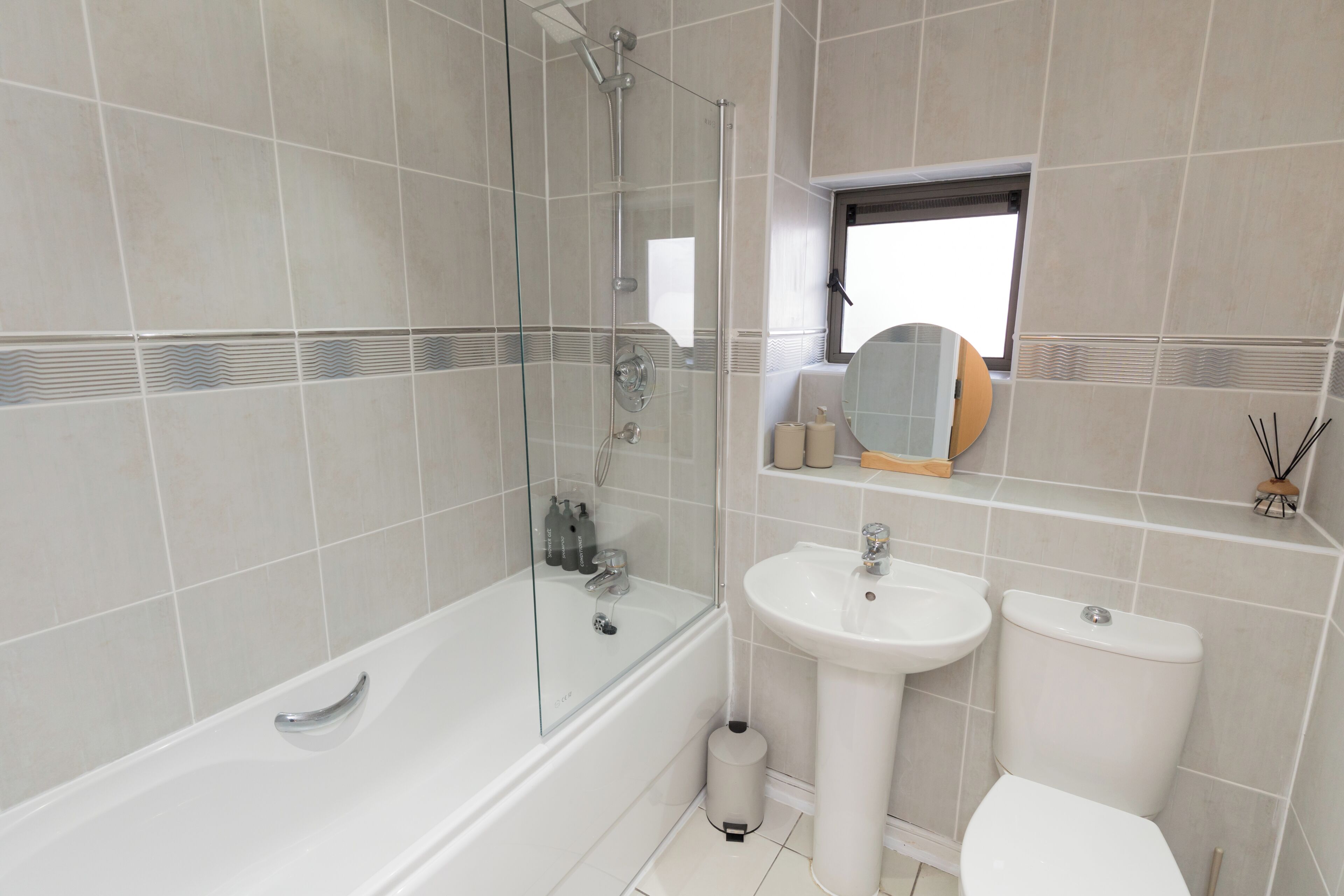 A modern bathroom with a bathtub, a sink, and a toilet.