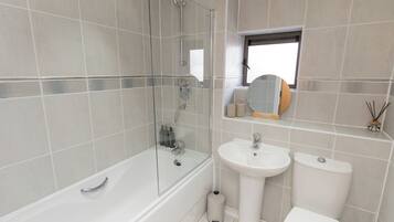 A modern bathroom with a bathtub, a sink, and a toilet.
