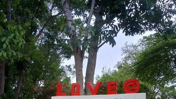 Un letrero para Stefaforana Nature Resort con un mensaje sobre el amor y una campana.