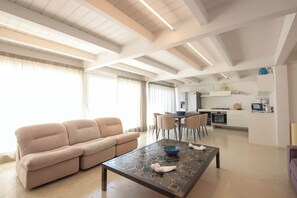 Ein modernes Wohnzimmer mit einer Couch, einem Couchtisch und einem Essbereich mit Stühlen.