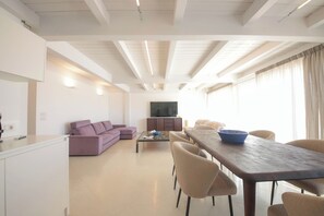 Ein modernes Wohnzimmer mit einer Couch, einem Couchtisch und einem Esstisch mit Stühlen.