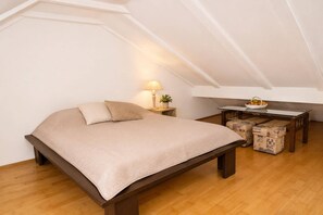 A bedroom with a bed, bedside table, lamp, and a small table with fruit. - Mrzeżyno holiday home, for 4 people (Mrzeżyno)