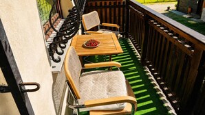 A balcony with a wooden table and two chairs, a metal railing, and a view of the surrounding area. - Holiday home for 6 people Mrzeżyno (Mrzeżyno)