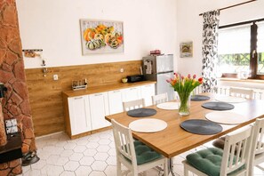 Ein Essbereich mit Holztisch, weißen Stühlen und einer Tulpenvase.