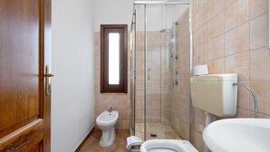 A bathroom with a shower, bidet, toilet, and a sink. - Daluef Alloggi - Room 9 (Assemini)