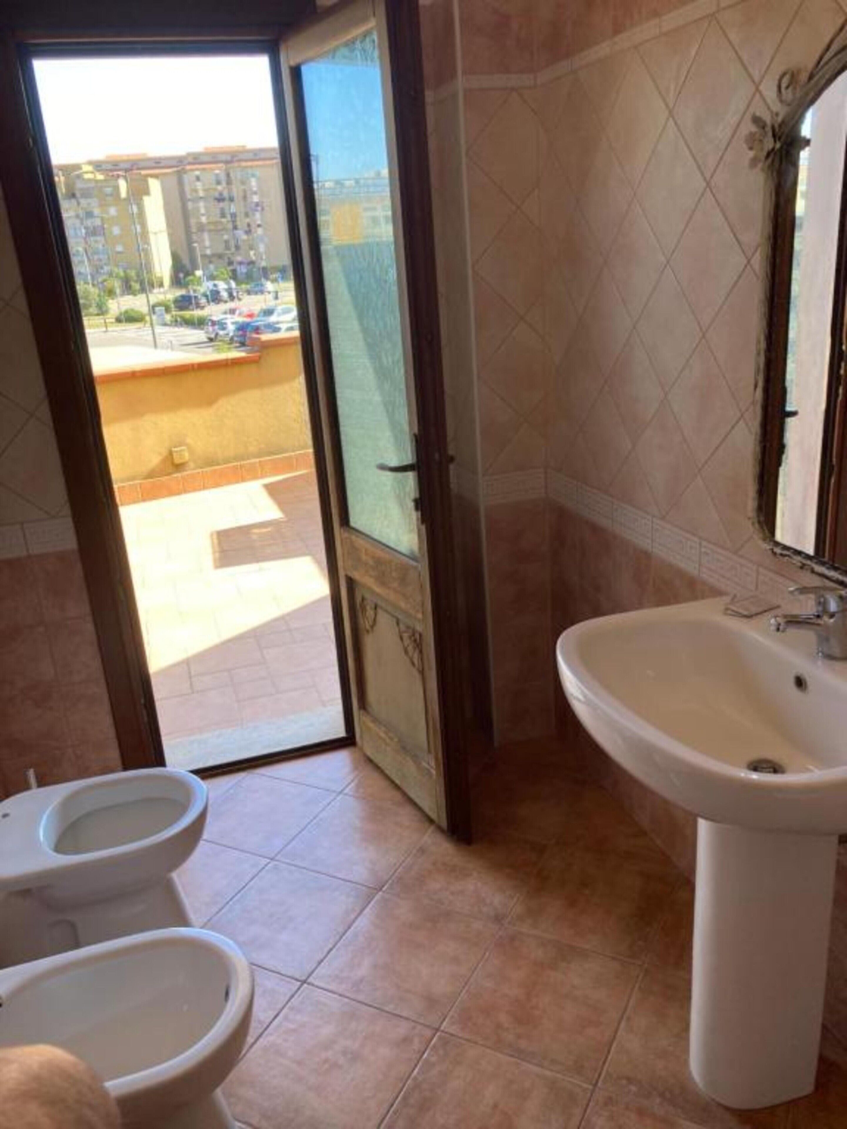 Une salle de bain équipée de toilettes, d’un bidet et d’un lavabo.